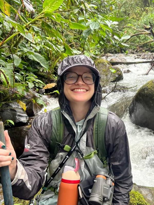 Dee Phillips stands by a stream in the cloud forests